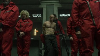 Movie still from “Money Heist” (2017), created by Álex Pina – A group of men in red suits standing next to each other in a room; Medium shot, Low angle