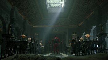 Movie still from “Money Heist” (2017), created by Álex Pina – A man in a red suit standing in a room with chairs; Wide shot, Low angle