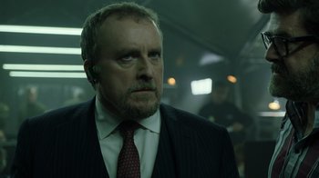 Movie still from “Money Heist” (2017), created by Álex Pina – A person wearing a suit and tie; Close Up shot, Low angle