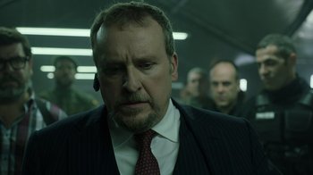 Movie still from “Money Heist” (2017), created by Álex Pina – A person wearing a suit and tie; Close Up shot, Low angle