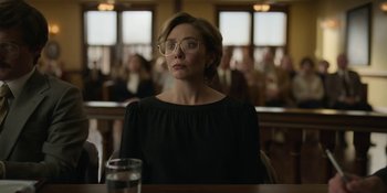 Movie still from “Love & Death” (2023), directed by Clark Johnson – A woman sitting at a table with a glass of water; Medium shot, Low angle