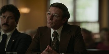 Movie still from “Love & Death” (2023), directed by Clark Johnson – An older man in a suit and tie sitting in front of a window; Close Up shot, Over the shoulder angle