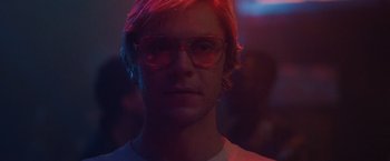 Movie still from “Monster” (2022), directed by Clement Virgo – A young man with pink hair wearing glasses; Close Up shot, Low angle