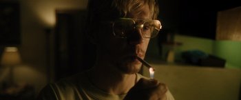 Movie still from “Monster” (2022), directed by Clement Virgo – A man with glasses is smoking a cigarette; Close Up shot, Low angle