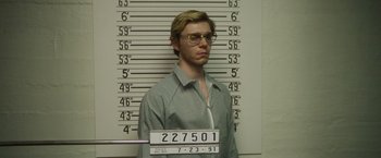 Movie still from “Monster” (2022), directed by Clement Virgo – A mugshot of a man in front of a wall; Medium shot, Low angle