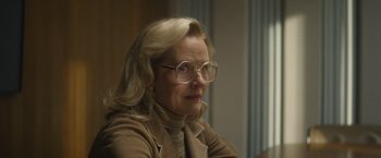 Movie still from “Monster” (2022), directed by Clement Virgo – An older woman wearing glasses and a brown jacket; Close Up shot, Over the shoulder angle