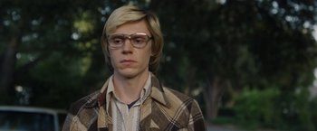 Movie still from “Monster” (2022), directed by Clement Virgo – A man with blonde hair wearing glasses and a plaid jacket; Close Up shot, Low angle