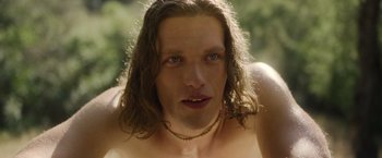 Movie still from “Monster” (2022), directed by Clement Virgo – A man with long hair and a necklace; Close Up shot, Low angle