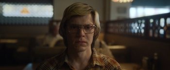 Movie still from “Monster” (2022), directed by Clement Virgo – A man with blonde hair wearing glasses and a plaid shirt; Close Up shot, Low angle