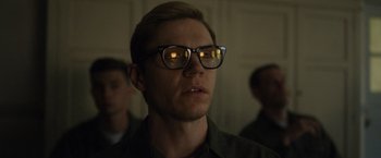 Movie still from “Monster” (2022), directed by Clement Virgo – A man wearing glasses and looking at the camera; Close Up shot, Low angle