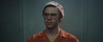 Movie still from “Monster” (2022), directed by Clement Virgo – A man with blonde hair wearing glasses and an orange shirt; Close Up shot, Low angle