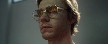 Movie still from “Monster” (2022), directed by Clement Virgo – A person wearing glasses; Close Up shot, Low angle