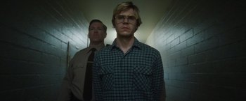 Movie still from “Monster” (2022), directed by Clement Virgo – A man standing next to another man in a hallway; Medium shot, Low angle