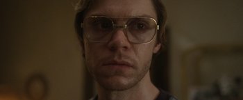 Movie still from “Monster” (2022), directed by Clement Virgo – A person wearing glasses; Close Up shot, Low angle