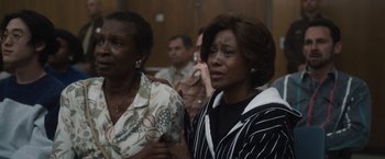 Movie still from “Monster” (2022), directed by Clement Virgo – Two women are standing in front of other people; Medium shot, High angle