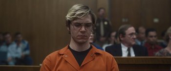 Movie still from “Monster” (2022), directed by Clement Virgo – A man in an orange prison uniform in a courtroom; Close Up shot, Low angle