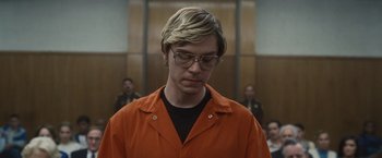 Movie still from “Monster” (2022), directed by Clement Virgo – A man in an orange shirt is standing in front of a wall; Close Up shot, Low angle