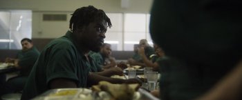 Movie still from “Monster” (2022), directed by Clement Virgo – A group of people sitting at a table eating food; Close Up shot, Over the shoulder angle