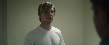 Movie still from “Monster” (2022), directed by Clement Virgo – A young man wearing glasses and a white t - shirt; Close Up shot, Low angle