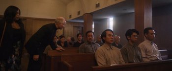 Movie still from “Monster” (2022), directed by Clement Virgo – A group of people sitting in pews in a church; Medium shot, Over the shoulder angle