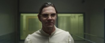 Movie still from “Monster” (2022), directed by Clement Virgo – A man wearing glasses and a white shirt; Close Up shot, Low angle