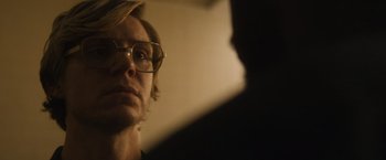 Movie still from “Monster” (2022), directed by Clement Virgo – A man wearing glasses looking at the camera; Close Up shot, Over the shoulder angle