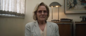 Movie still from “Monster” (2022), directed by Clement Virgo – An older woman wearing glasses and a jacket; Close Up shot, Low angle
