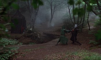 Movie still from “Monty Python and the Holy Grail” (1975), directed by Terry Gilliam – Two people are fighting in the middle of the woods; Wide shot, High angle