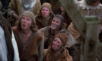 Movie still from “Monty Python and the Holy Grail” (1975), directed by Terry Gilliam – A group of men in a crowd of people wearing hats; Medium shot, Low angle
