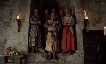 Movie still from “Monty Python and the Holy Grail” (1975), directed by Terry Gilliam – A group of people dressed in medieval costumes; Wide shot, Low angle