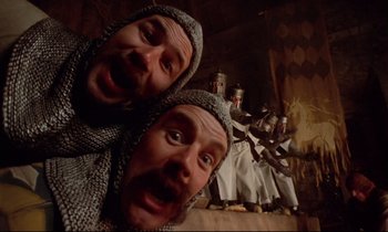 Movie still from “Monty Python and the Holy Grail” (1975), directed by Terry Gilliam – Two men in chainmaille suits are posing for a picture; Close Up shot, Low angle