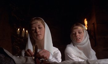 Movie still from “Monty Python and the Holy Grail” (1975), directed by Terry Gilliam – A couple of women sitting next to each other in a room; Medium shot, Low angle