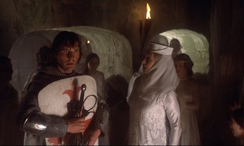 Movie still from “Monty Python and the Holy Grail” (1975), directed by Terry Gilliam – A group of people dressed in medieval clothing; Medium shot, Over the shoulder angle