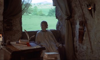 Movie still from “Monty Python and the Holy Grail” (1975), directed by Terry Gilliam – A woman sitting at a table in front of an open window; Wide shot, High angle