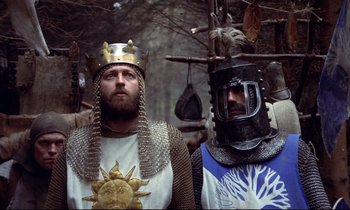 Movie still from “Monty Python and the Holy Grail” (1975), directed by Terry Gilliam – Two men dressed as medieval knights in a forest; Medium shot, Low angle