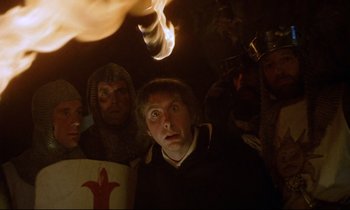 Movie still from “Monty Python and the Holy Grail” (1975), directed by Terry Gilliam – A group of people standing next to each other in a room; Close Up shot, Low angle