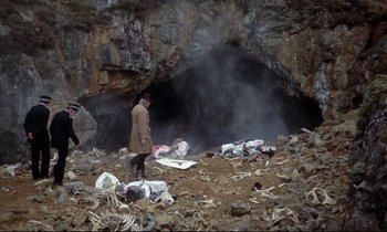 Movie still from “Monty Python and the Holy Grail” (1975), directed by Terry Gilliam – A man standing in front of an open cave; Wide shot, High angle