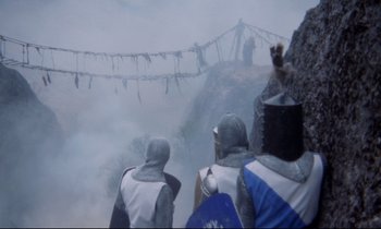 Movie still from “Monty Python and the Holy Grail” (1975), directed by Terry Gilliam – A group of people standing on top of a mountain; Wide shot, High angle