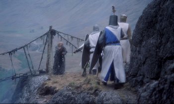 Movie still from “Monty Python and the Holy Grail” (1975), directed by Terry Gilliam – A group of people dressed in medieval costumes; Wide shot, High angle