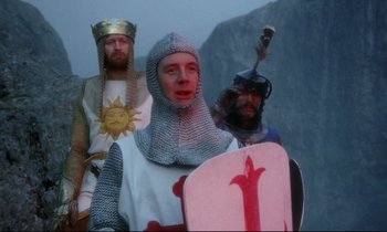 Movie still from “Monty Python and the Holy Grail” (1975), directed by Terry Gilliam – A group of men dressed in medieval costumes; Medium shot, Low angle