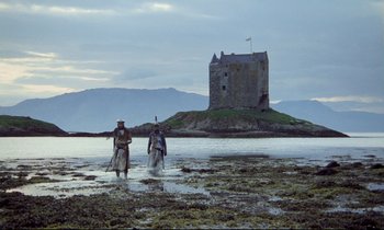Movie still from “Monty Python and the Holy Grail” (1975), directed by Terry Gilliam – Two people walking in the water near a castle; Extreme Wide shot, Low angle