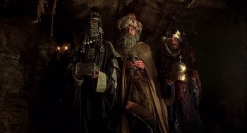 Movie still from “Life of Brian” (1979), directed by Terry Jones – A group of people dressed up in costumes in a cave; Medium shot, Low angle