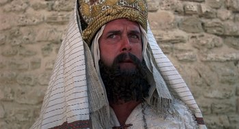 Movie still from “Life of Brian” (1979), directed by Terry Jones – A man with a beard wearing a crown; Close Up shot, Low angle