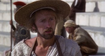 Movie still from “Life of Brian” (1979), directed by Terry Jones – A man with a beard and a hat on; Close Up shot, Over the shoulder angle