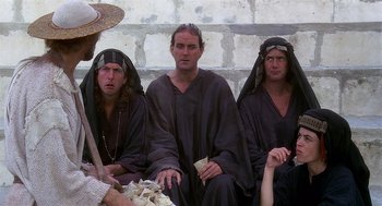 Movie still from “Life of Brian” (1979), directed by Terry Jones – A group of men sitting next to each other on the ground; Medium shot, High angle