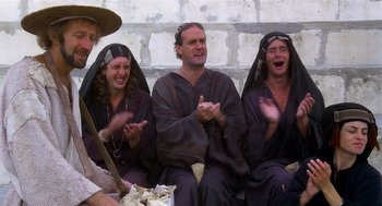 Movie still from “Life of Brian” (1979), directed by Terry Jones – A group of people dressed in medieval garb; Medium shot, Low angle