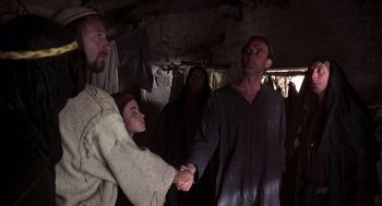 Movie still from “Life of Brian” (1979), directed by Terry Jones – Two men and a woman holding hands in a cave; Medium shot, Low angle