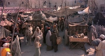 Movie still from “Life of Brian” (1979), directed by Terry Jones – A group of people standing around a market; Extreme Wide shot, High angle