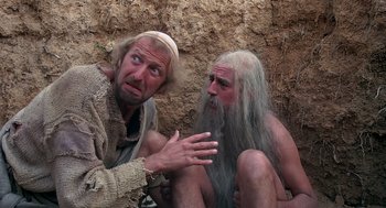 Movie still from “Life of Brian” (1979), directed by Terry Jones – A man and a man with long white hair and a beard; Medium shot, Low angle