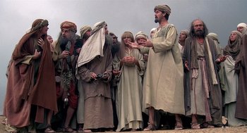 Movie still from “Life of Brian” (1979), directed by Terry Jones – A group of men standing next to each other on a field; Wide shot, Low angle